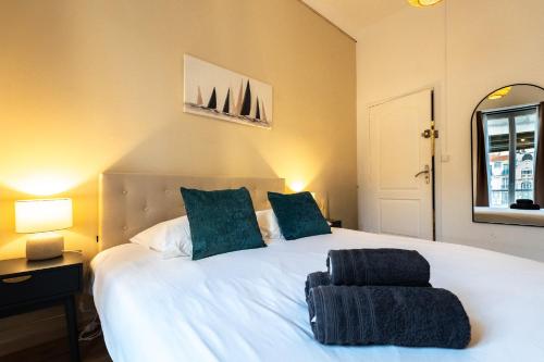 a bedroom with a large white bed with two blue pillows at Chambre 2 La Calada in Nice