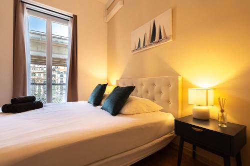 a bedroom with a large white bed with a window at Chambre 2 La Calada in Nice