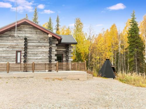 a log cabin in the woods with a wooden fence at Holiday Home Kojamopirtit by Interhome in Kolari