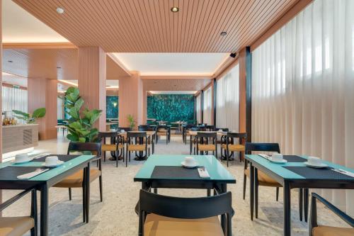 a restaurant with tables and chairs and windows at The Editory Garden Carmo Funchal in Funchal