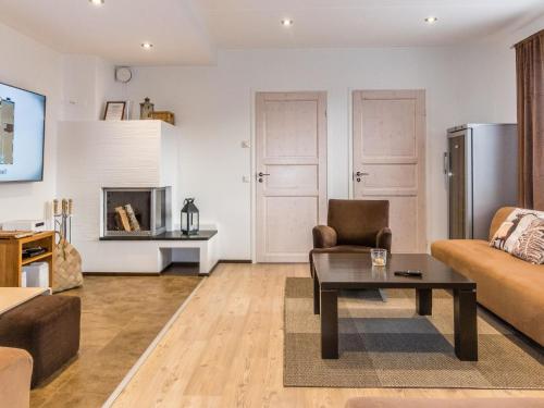a living room with a couch and a table at Holiday Home Levinkolmio c6 by Interhome in Levi