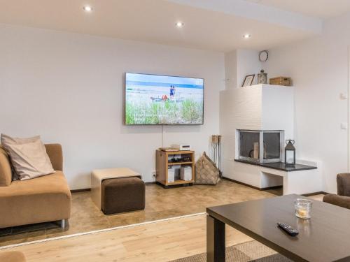 a living room with a couch and a tv on the wall at Holiday Home Levinkolmio c6 by Interhome in Levi