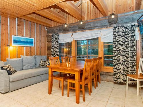 a dining room with a wooden table and a couch at Holiday Home Joikupirtti a by Interhome in Pyhätunturi