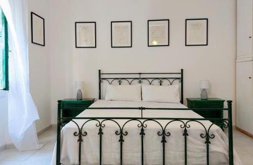 a bedroom with a black bed with four pictures on the wall at Downtown flat historic Reggio in Reggio di Calabria