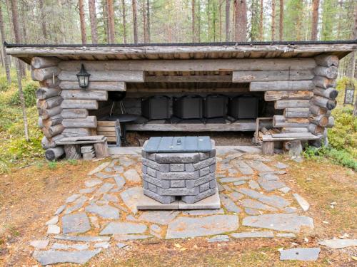 a log cabin with a fireplace in the woods at Holiday Home Pikku pyhis by Interhome in Pyhätunturi