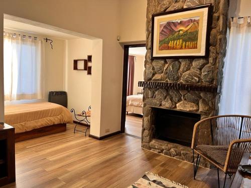 a living room with a stone fireplace and a bed at La Quinta Resort in Merlo
