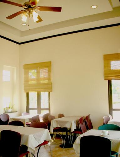 a dining room with tables and chairs and a ceiling fan at River Resort & Spa in Sa Kaeo