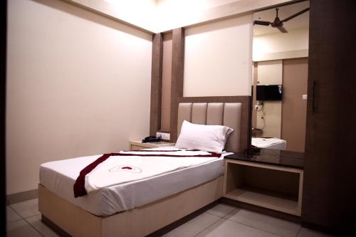 a bedroom with a large bed and a mirror at Hotel Silver Palace in Haldwāni