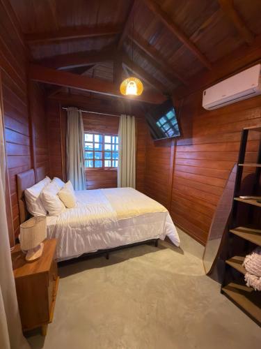 a bedroom with a bed in a room with wooden walls at Lagoon Paradise in Fortim