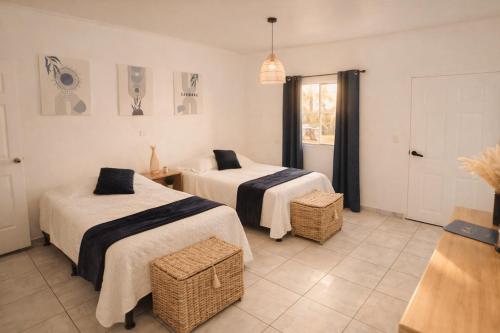 a hotel room with two beds and a window at Habitación Agua - Villa Valle Campo in Nahuizalco