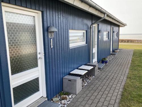 a blue building with a bench next to it at Apartment Elevus - 10m from the sea by Interhome in Bogense