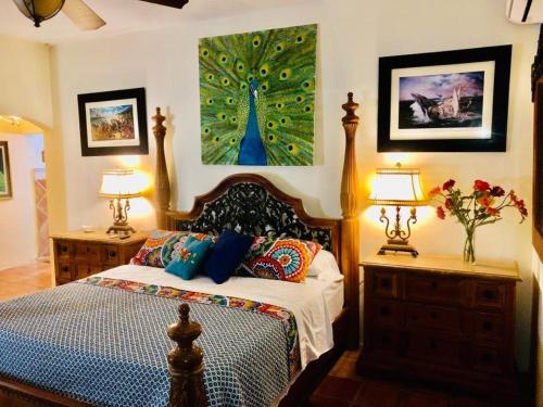 una camera da letto con un letto, due lampade e un dipinto di un albero di Villa Vassallo a Ponce