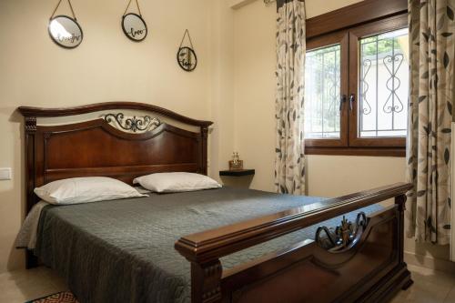 a bedroom with a bed and a window with clocks on the wall at ΠΟΛΥΤΕΛΕΣ -ΜΟΝΤΕΡΝΟ ΔΙΑΜΕΡΙΣΜΑ in Larisa