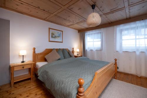 a bedroom with a bed and two windows at Ferienhaus Valsora in Sölden