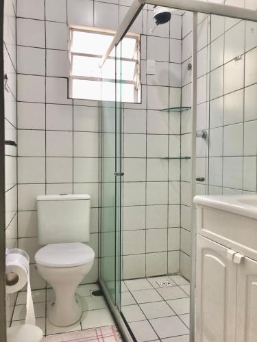 a bathroom with a toilet and a glass shower at Casa três quartos em condomínio in Garanhuns