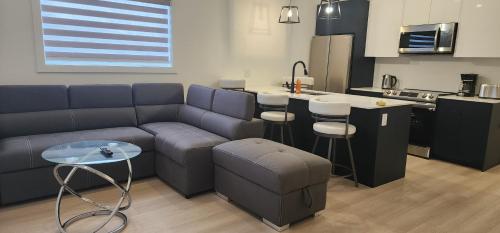 a living room with a couch and a kitchen at ChessKings Apartments in Winnipeg