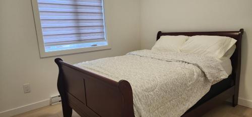 a bed in a bedroom with a window with a shutter at ChessKings Apartments in Winnipeg