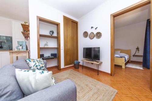 a living room with a couch and a tv at A56 - Westway Rossio Holiday Place in Luz