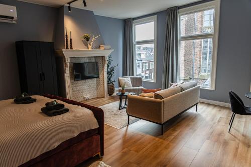 a bedroom with a bed and a couch and a fireplace at Hartje Centrum in Zwolle