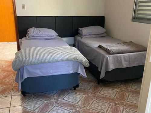 two beds sitting next to each other in a room at Hotel Pousada Villa Itália - Cabreúva in Cabreúva