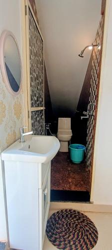a bathroom with a sink and a toilet at GS Home on the Bay- Super Sea & Garden view Glass studio apartment in Vagator