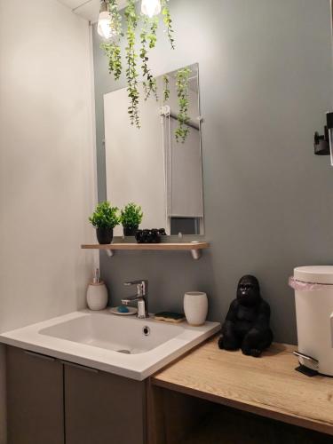 a bathroom with a sink and a teddy bear on a counter at Le Havre de la jungle in Montereau