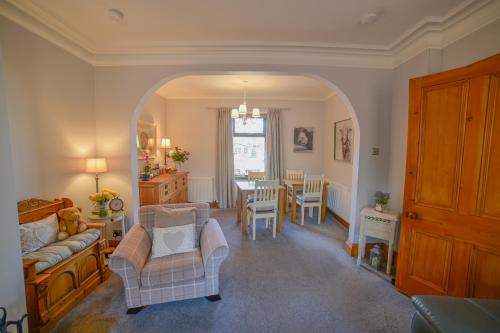ein Wohnzimmer mit Sofa, Stühlen und einem Tisch in der Unterkunft Kylelachin in Dingwall