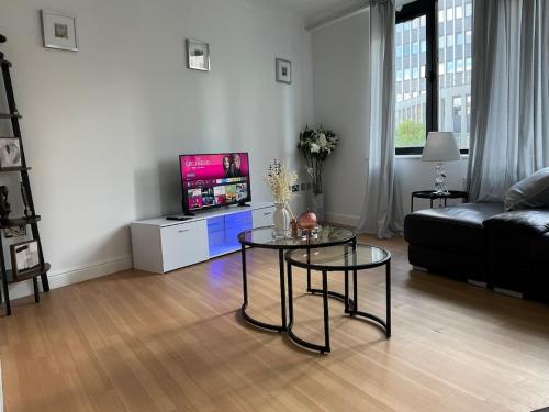 a living room with a table and a couch at Chill At Gee's in Nottingham