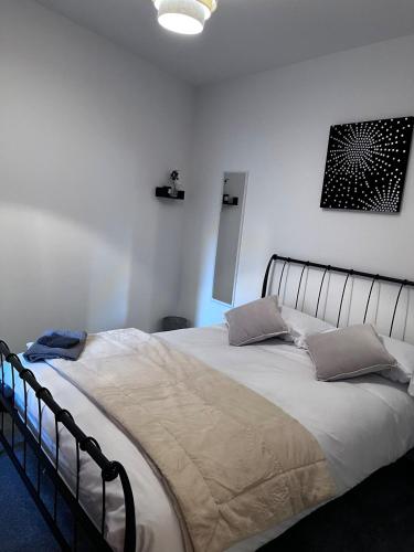 a bedroom with a large bed with two pillows at Chill At Gee's in Nottingham