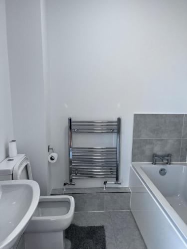 a bathroom with a toilet and a tub and a sink at Chill At Gee's in Nottingham