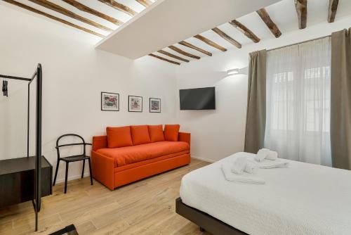 a bedroom with a bed and a orange couch at Il Fiore del Prione in La Spezia