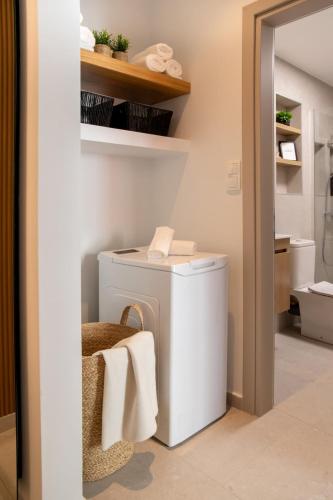a bathroom with a white washing machine in a room at Ophelia's - Luxury Apartment in Volos