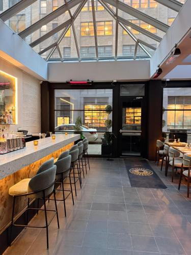 a restaurant with a bar with chairs and tables at Four Points by Sheraton Manhattan SoHo Village in New York
