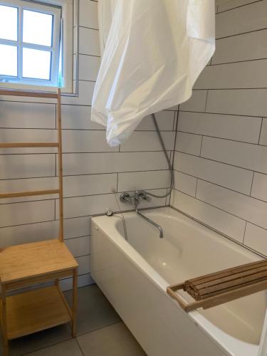 a white bath tub in a bathroom with a window at Annekset - Bjørnø in Faaborg