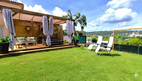 a backyard with a patio with a table and chairs at Charmant studio avec terrasse et jardin au cœur de la Provence 4 étoiles in Camps-la-Source