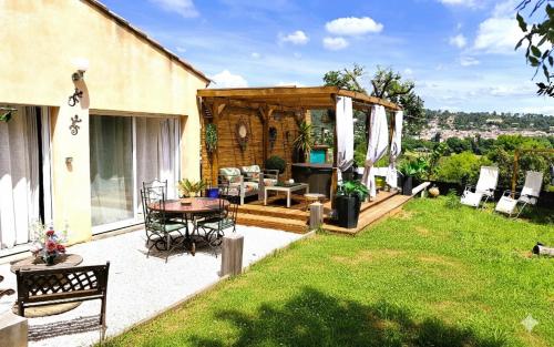a backyard with a patio with a table and chairs at Charmant studio avec terrasse et jardin au cœur de la Provence 4 étoiles in Camps-la-Source