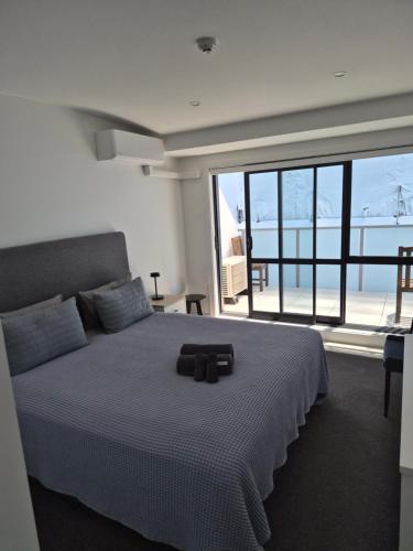 a bedroom with a large bed with a large window at 2 Room Luxury Beach Escape 112sq Mt Maunganui in Mount Maunganui