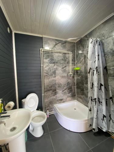 a bathroom with a tub and a toilet and a sink at Шпінь 3 in Vorokhta