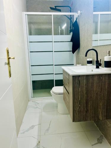 a bathroom with a shower and a toilet and a sink at CASA ADELA - Playa 2 min - Aire Acondicionado - WIFI - Parking cercano in Barbate