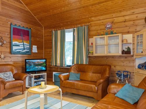 a living room with leather chairs and a television at Holiday Home Sallassi by Interhome in Salla