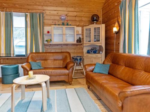 a living room with two leather couches and a table at Holiday Home Sallassi by Interhome in Salla