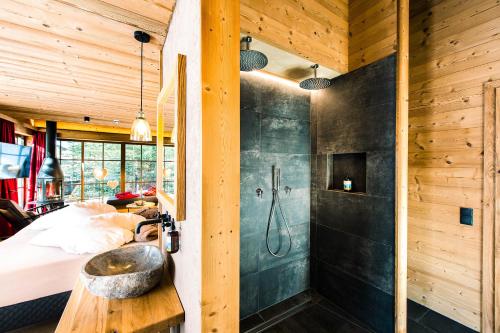 a bedroom with a bed and a shower and a sink at Mons Silva Private Luxury Chalets in Racines
