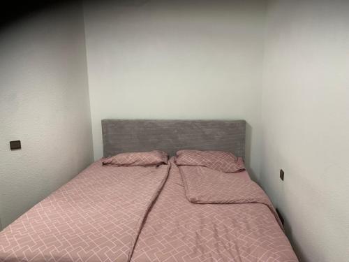 a bed with pink comforter and two pillows at KM APPARTS 5 Wesel in Wesel