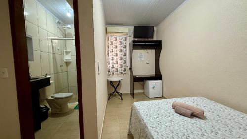a small room with a bed and a bathroom at Hotel Consalter in Rodeio Bonito