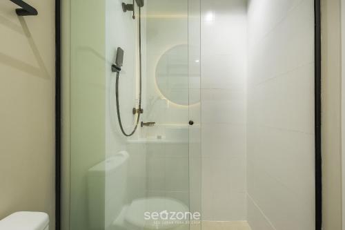a shower with a glass door next to a toilet at Studio in center of Rosa, rooftop w/ pool RSO0031 in Imbituba
