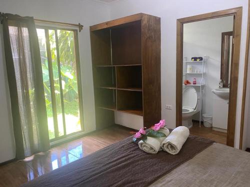 a bedroom with a bed with towels and a toilet at Pumakari Rapa Nui in Hanga Roa