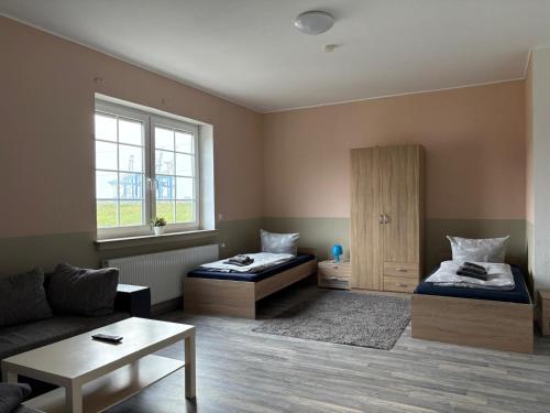 a living room with two beds and a couch at Monteurwohnungen Am Deich - Ideal für Langzeitaufenthalte in ruhiger Lage in Bremerhaven