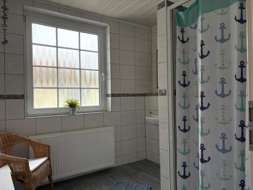 a bathroom with a shower curtain with an anchor at Monteurwohnungen Am Deich - Ideal für Langzeitaufenthalte in ruhiger Lage in Bremerhaven