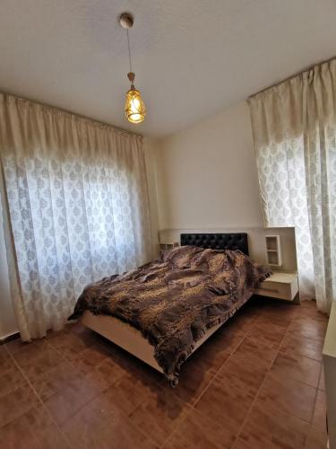 a bedroom with a bed in a room with curtains at Jubeiha Home in Amman