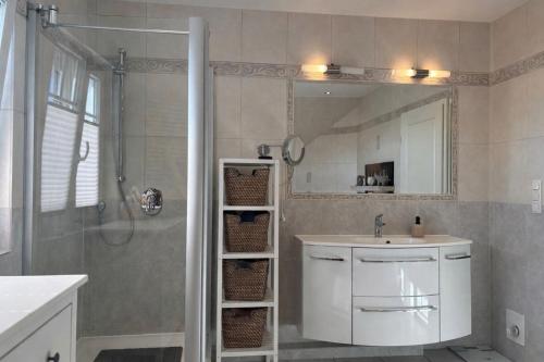 a bathroom with a sink and a shower with a mirror at 4 Zimmer Ostseetraum in Gneversdorf